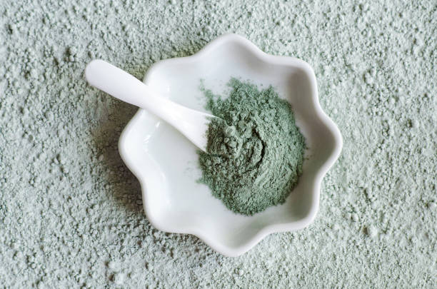 Green (blue) bentonite clay powder in a bowl. Clay texture close up. Diy face mask and body wrap recipe. Natural beauty treatment and spa. Top view, copy space Green (blue) bentonite clay powder in a bowl. Clay texture close up. Diy face mask and body wrap recipe. Natural beauty treatment and spa. Top view, copy space green clay stock pictures, royalty-free photos & images