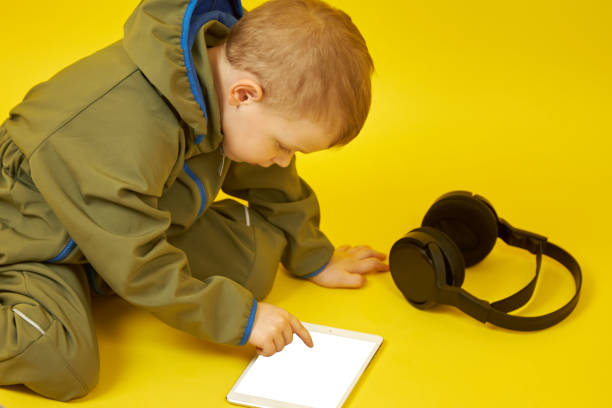 istock The child uses a digital tablet and wireless headphones 1323006130