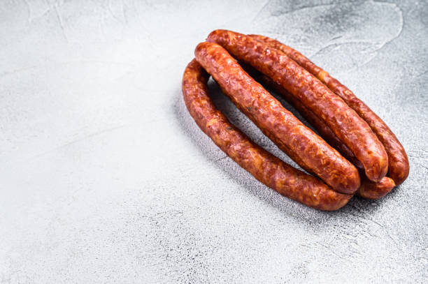 istock Hot Smoked sausages on a rustic table. White background. Top view. Copy space 1323006777