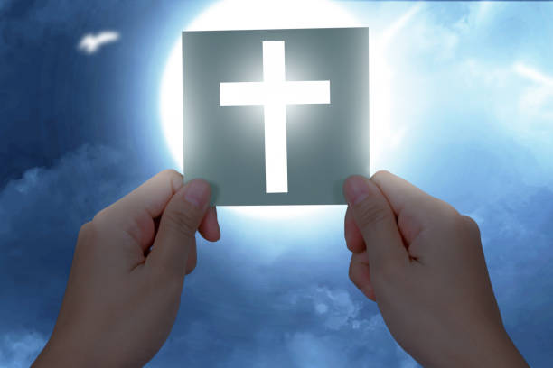 istock Human hand holding paper with a Christian cross 1323008056
