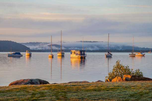 istock Sunrise waterscape with boats, light cloud and fog 1323009297