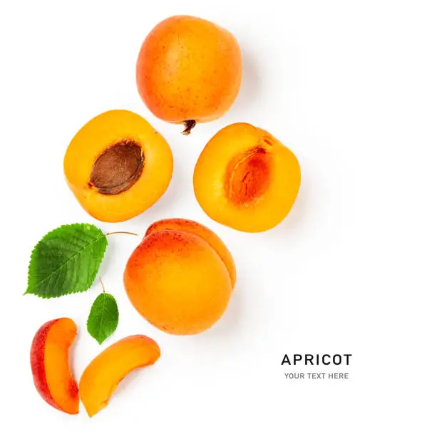 Apricot fruit and green leaves creative layout isolated on white background. Healthy eating and dieting food concept. Summer fresh fruits composition and design element. Top view, flat lay