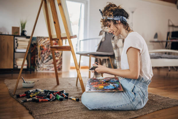 istock Beautiful woman painter mixing colors 1323012624