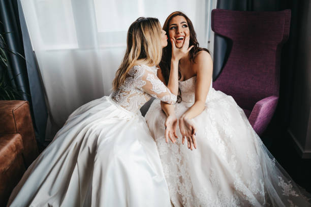 istock Young lesbian couple in wedding dresses 1323013997