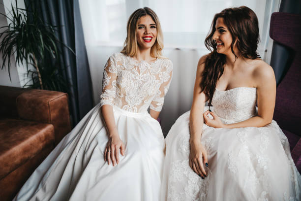 istock Young lesbian couple in wedding dresses 1323013998