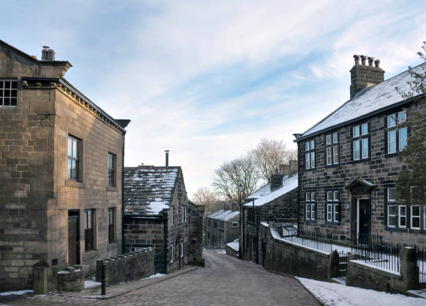 view of the main street in the village of Heptonstall in west Yorkshire with snow on roofs with blue winter sky view of the main street in the village of Heptonstall in west Yorkshire with snow on roofs with blue winter sky pennines photos stock pictures, royalty-free photos & images