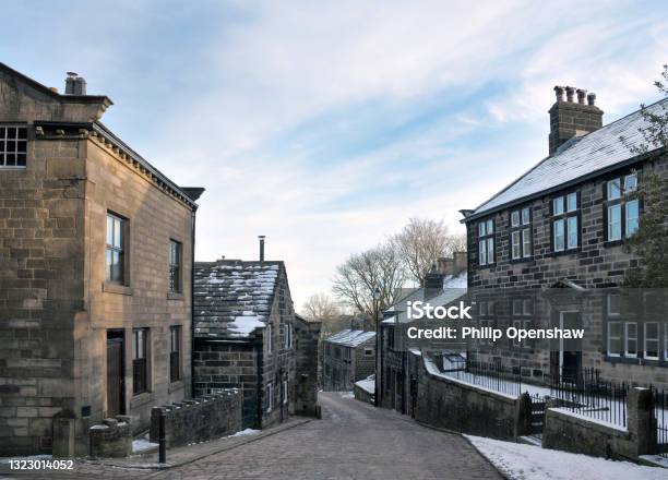 View Of The Main Street In The Village Of Heptonstall In West Yorkshire With Snow On Roofs With Blue Winter Sky Stock Photo - Download Image Now