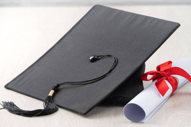 istock Graduation academic cap with diploma on wooden table background. 1323018592