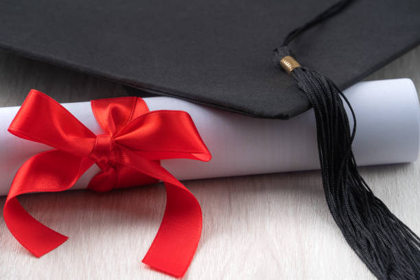 istock Graduation academic cap with diploma on wooden table background. 1323018670