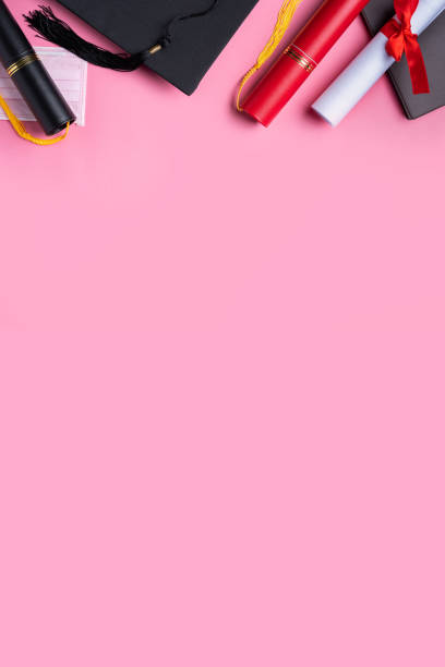istock Graduation academic cap with diploma and mask isolated on pink table background. 1323018932