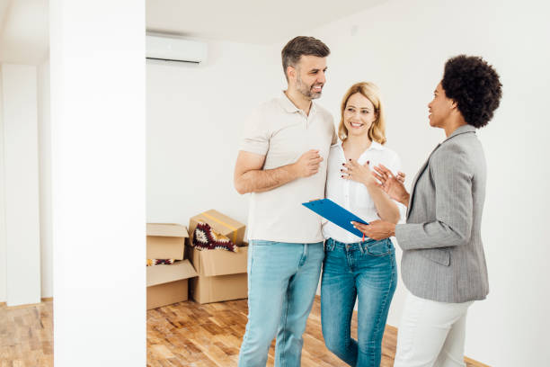 istock Real estate agent explaining a house purchase procedure to a happy couple 1323020109