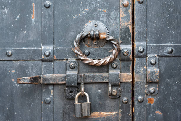 istock Padlock is hinged on latch of old door. 1323020122