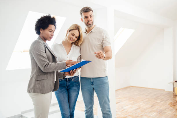 istock Real estate agent showing a purchase contract to their clients 1323020135