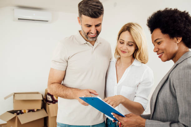 istock Happy couple making a contract for buying house with their agent 1323020147