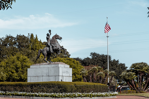 A beautiful sunny day in Jackson Square. A tourist takes photographs of the monument of President Andrew Jackson in the French Quarter of New Orleans, Louisiana.