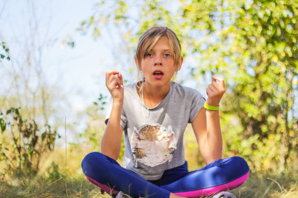 defocus kaukaska preteen dziewczyna praktykuje jogę w parku, lesie, na zewnątrz, na zewnątrz. medytacja, koncentracja, mantra. wellness styl życia. portret poważnej dziewczyny. tło przyrody. nieokreślenia - zen like nature breathing exercise sitting zdjęcia i obrazy z banku zdjęć