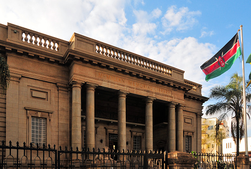 Nairobi, Kenya: 1930s neo-classical facade of the McMillan Memorial Library, oldest library in Nairobi - entrance with lions on Banda Street - flag of Kenya