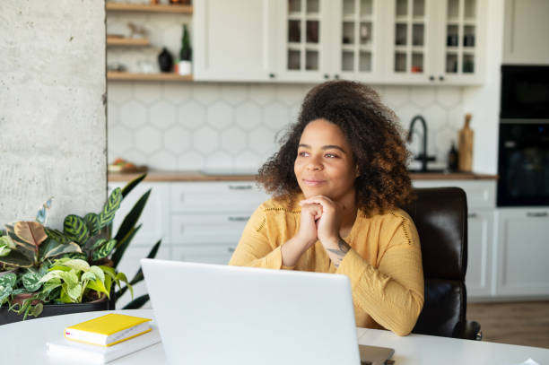 istock Young African-American woman using laptop at home 1323026367
