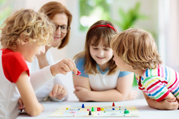 jogo de tabuleiro em família. crianças brincam. - leisure games dice indoors table - fotografias e filmes do acervo