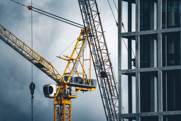 construction tower cranes on a building site - engineering nobody contemporary new imagens e fotografias de stock