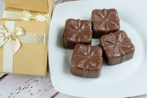 istock Four Brazilian honey cakes next to golden gift boxes. 1323031256