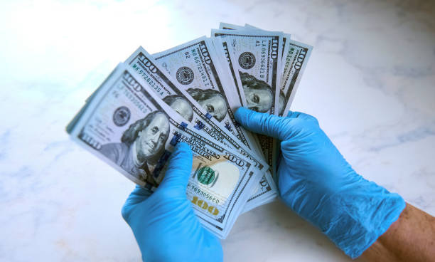 istock secure money transfer. hand in a rubber glove takes money. 1323031467