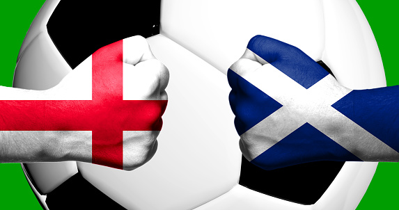 Flags of England and Scotland painted on two clenched fists facing each other with closeup 3d football soccer ball in the background. Mixed media football match game concept