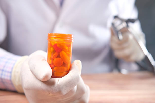 istock doctor hand in protective gloves holding pill container 1323034742