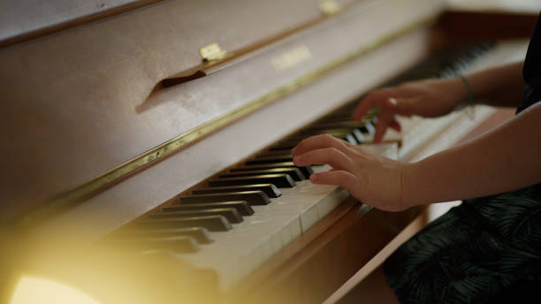 istock Boy playing the piano. Home education. Close up on hands 1323035003