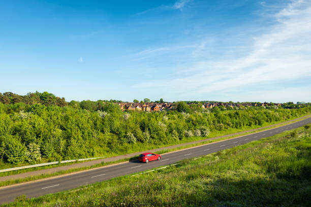 uk motorway road traffic over new build town development in england - town rural scene road new england imagens e fotografias de stock