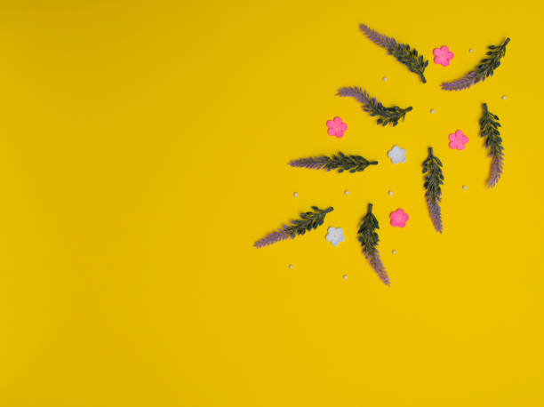 istock Small purple, pink and white flowers with white beads on yellow background. Spring, summer concept. Flat lay style with copy space 1323036241