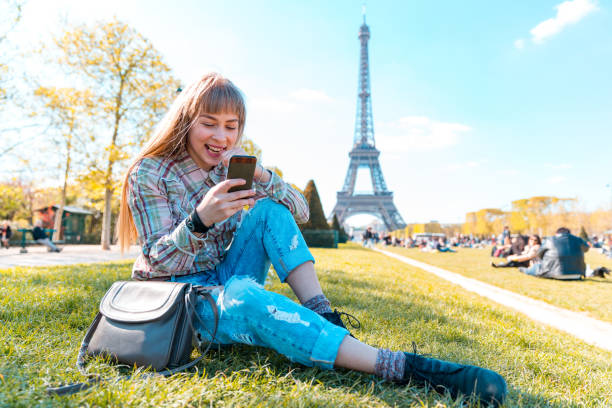 istock Happy girl using phone in Paris with Eiffel Tower on background 1323036748