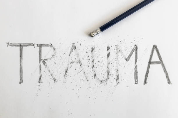 Erasing trauma. Trauma written on white paper with a pencil, partially erased with an eraser. Symbolic for overcoming trauma or treating trauma. Erasing trauma. Trauma written on white paper with a pencil, partially erased with an eraser. Symbolic for overcoming trauma or treating trauma. post traumatic stress disorder photos stock pictures, royalty-free photos & images
