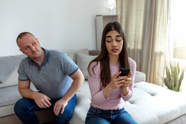 istock Jealous curious man spying his girlfriend's smartphone 1323038005