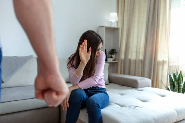 foto recortada de una joven tratando de protegerse del puño apretado de un hombre. - violence domestic violence women domestic life fotografías e imágenes de stock