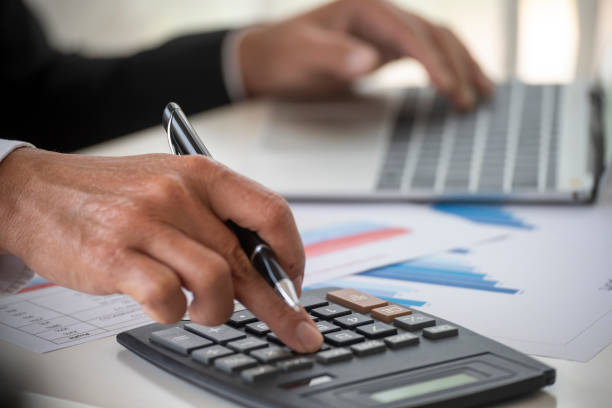 Close up business man hands using calculator counting tax financial bill. Man hands calculating number, data, graph, chart audit planning accountancy on business report. Tax audit Finacial concept. de cerca las manos del hombre de negocios usando la calculadora que cuenta la factura financiera de impuestos. manos del hombre calculando el número, los datos, el gráfico, la contabilidad de la planificación de la auditoría de la carta en informe de n