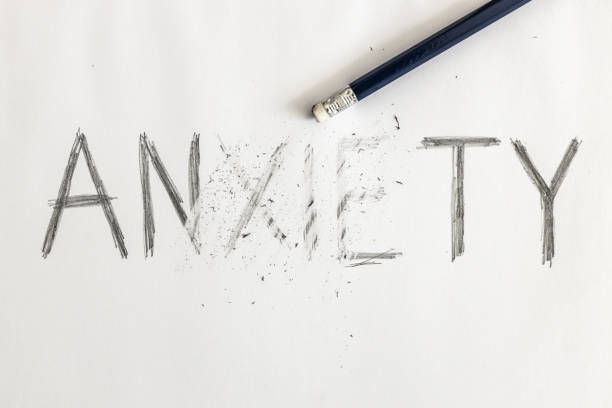 erasing anxiety. anxiety written on white paper with a pencil, partially erased with an eraser. symbolic for overcoming anxiety or treating anxiety. - ansiedade imagens e fotografias de stock