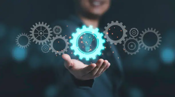 Photo of Businessman holding blue mechanical gear with virtual light bulb for creative thinking idea and innovation concept.