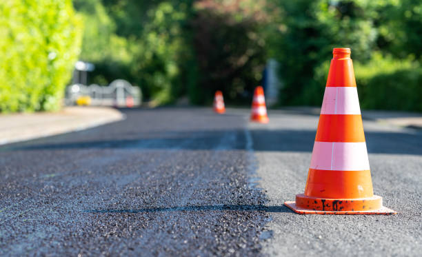 istock Construction cones marking part of road with a layer of fresh asphalt. 1323042980