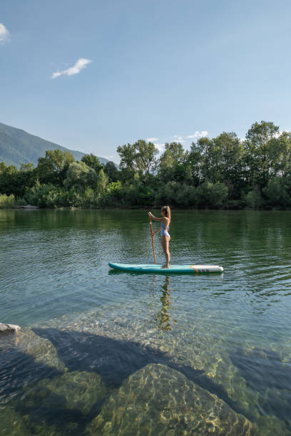 istock Woman paddling on a stand up paddle board 1323042999