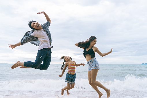 Asian Family jumping together at beach with kids happy vacation travel beach concept