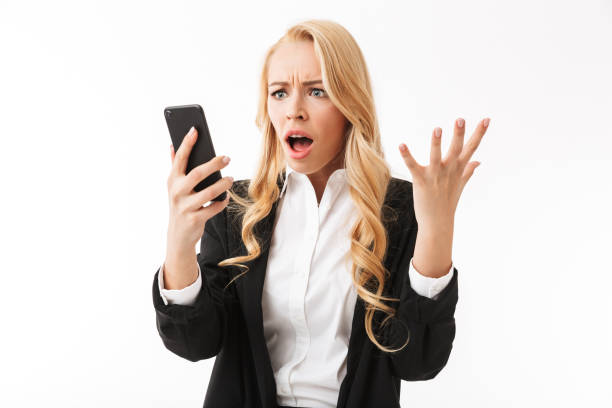 istock Shocked business woman posing isolated over white background wall using phone. 1323045516