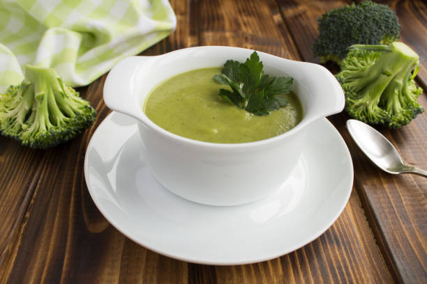 zuppa vegetariana di purea di broccoli nella ciotola bianca sullo sfondo marrone in legno - cream of broccoli foto e immagini stock