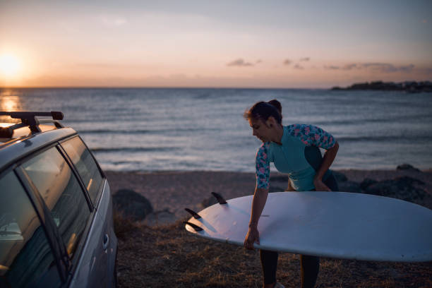 istock Woman preparing for surfing at sunrise. 1323048803