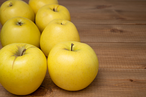 Yellow ripe Golden apples on wooden background. Tasty and sweet fruits.