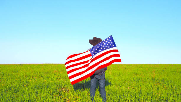 istock A man with the USA flag on natural landscape background. 1323051277