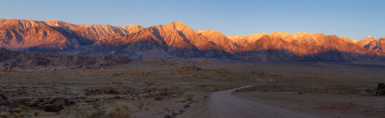 Panorama of Movie Road in Alabama Hills leading into the Sierra Nevadas lit by brilliant morning sun