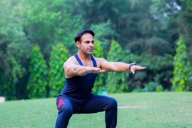 Shot of a sporty young man doing exercise and stretching:- stock photo Healthy Lifestyle, Running, Exercising, stretching, India, Indian ethnicity, three quarter length stock pictures, royalty-free photos & images