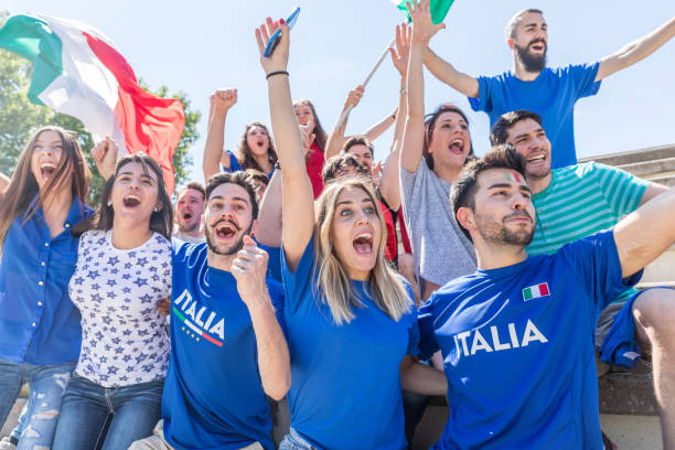 istock Italian supporters celebrating at stadium with flags 1323055580