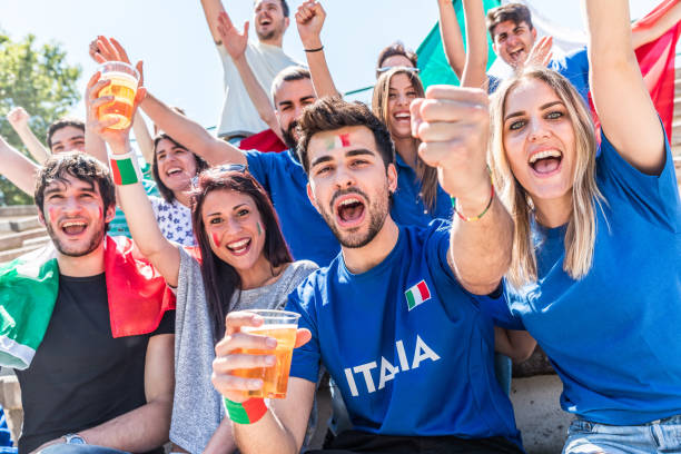 istock Italian supporters celebrating at stadium with flags 1323055614